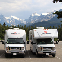 Photo two RV's with mountains in background