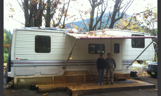 Husband and wife standing in front of their RV