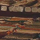 A man stands in an outdoor market, with tables full of handmade crafts.