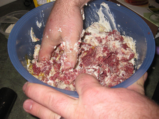 Chad is mixing the ground beef mixture with his hands.