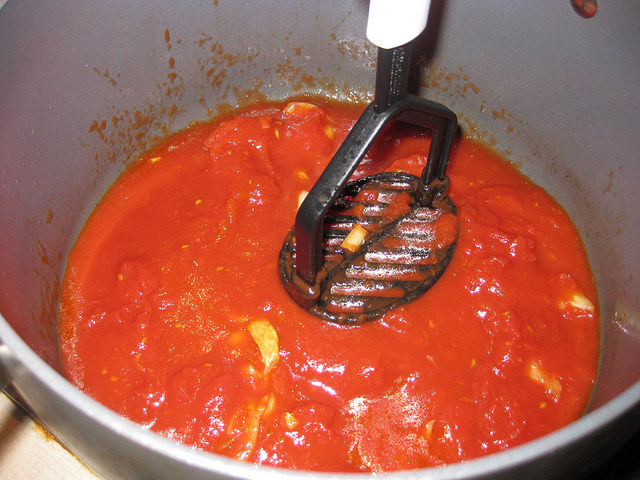 Step two: Crush the tomatoes carefully with a potato masher.
