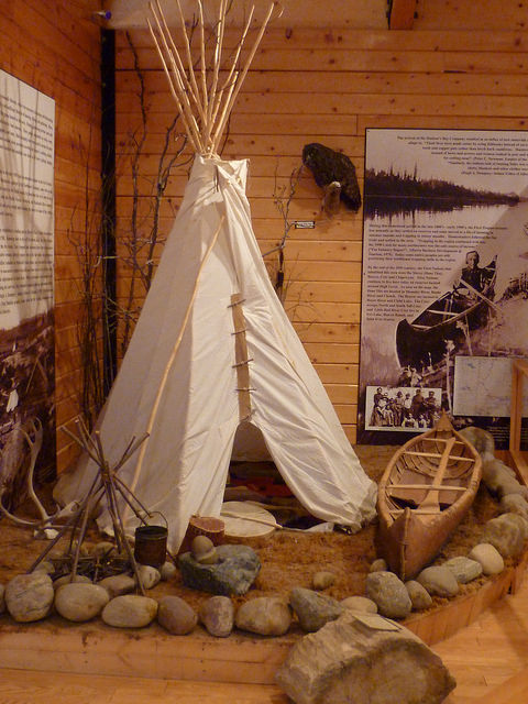 A display of a native camp with a tepee and a canoe.