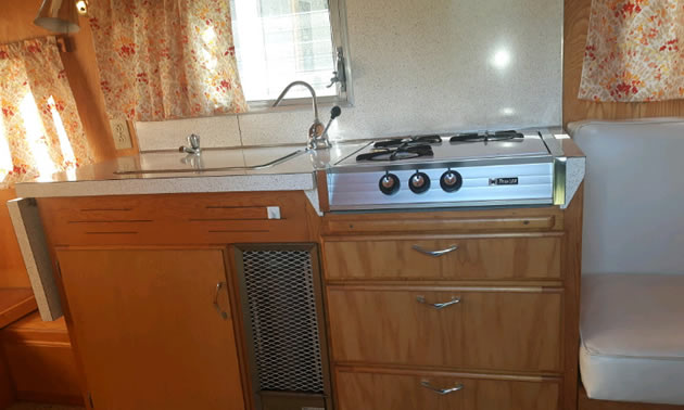 Interior of trailer, showing stove and kitchen area.