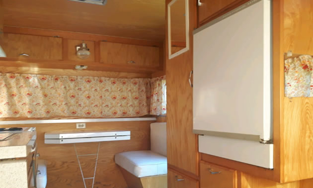 Interior of trailer, showing fridge and seating. 