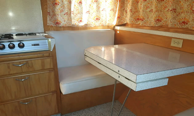Interior of trailer, showing table and seating.
