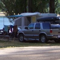 My husband and I were visiting the Nelson/Balfour area for the first time in our 1970-something Boler travel trailer. On arrival at the campsite, we were assigned a lakefront spot and when we parked, we were the only people there; however, as we set up camp, neighbours arrived to the left and to the right of us. Once we had set up camp, we decided to take a drive to Balfour and as we were pulling out of our campsite, I looked back at our trailer and this picture is what I saw. The difference in size between us and our neighbors really tickled our funny bones. We've now graduated to a 28' fifth wheel but we still talk about our little Boler, how much fun we had in it and how simple life was back then.