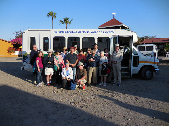 A group with Baja Amigos standing in front of a small tour bus ready to go on a tour.