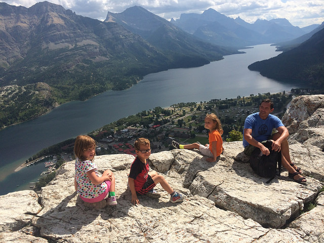 Minet 8, Myah and Mikey 6 together with their dad, Dave, are enjoying the rewarding view after their climb up the bear's hump at Waterton National Park.