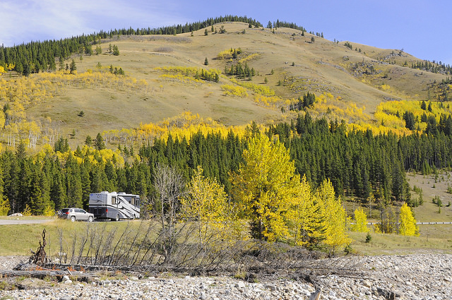 Wendy and Ron Elliott's rig at a pull-out on a gorgeous September day with the backdrop of fall colours seen on the trees behind the rig.