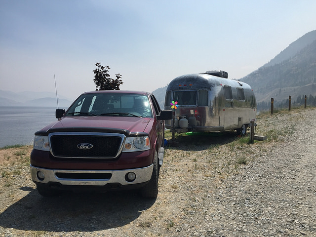 Dave Barton and Anne Bovon's vintage airstream parked in front of a lake. 