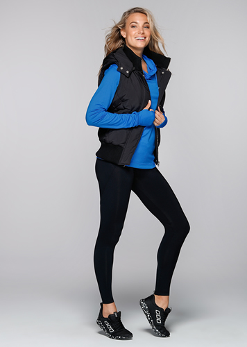 A full-body picture of the black vest being worn by the model.