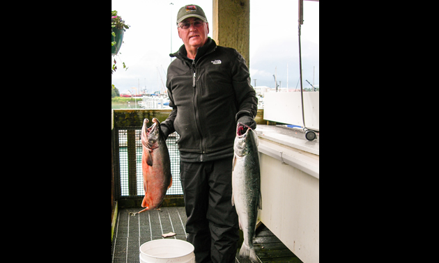Riley displays the day's catch of two silver salmon in Valdez, AK.