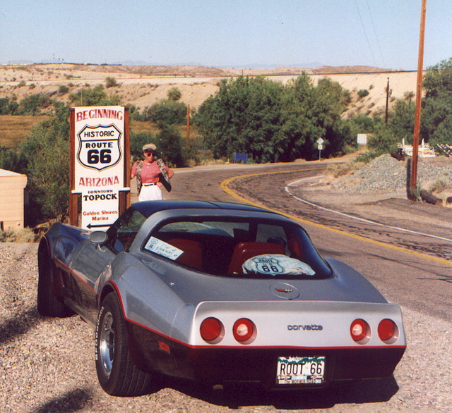 Picture of a Corvette stopped on the side of the Route 66 sign.