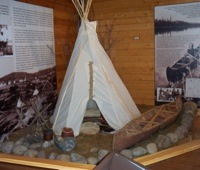 A display of a native tipee and birchbark canoe. 