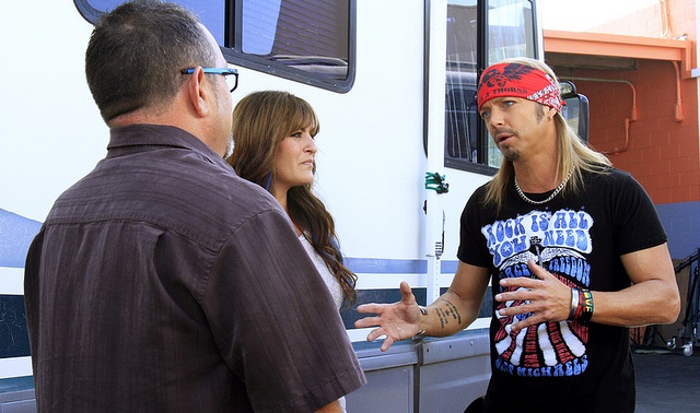 Bret Michaels talking to a couple in front of their RV. 