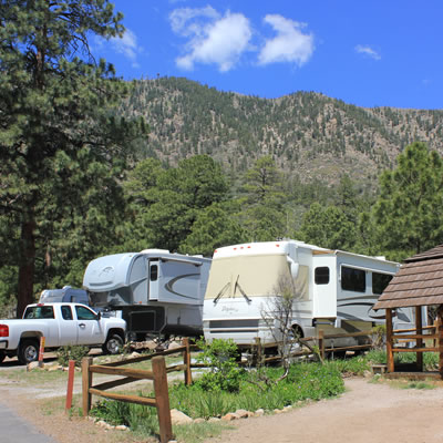 A campground in Arizona, with mountain in background and large RV parked in camping spot. 
