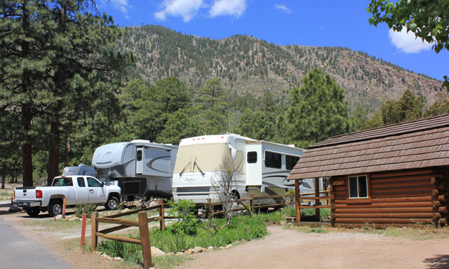 A campground in Arizona, with mountain in background and large RV parked in camping spot. 