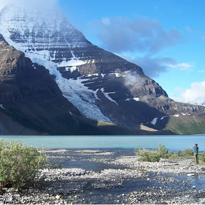 Picture of photographer taking picture of towering mountain. 