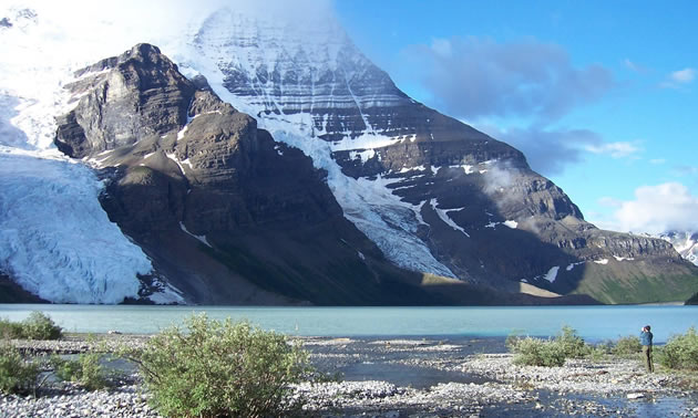 Picture of photographer taking picture of towering mountain. 