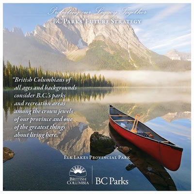 Picture of BC park, with red canoe sitting in fog-shrouded lake, mountain in background. 