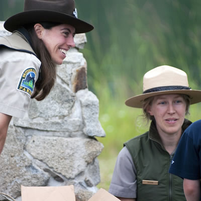 Picture of two park rangers interacting with a child. 