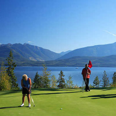 Group of golfers on course with lake in background. 