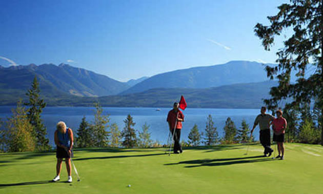 Group of golfers on course with lake in background. 