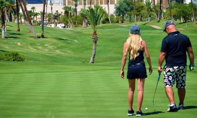 Man and woman on golf course green. 