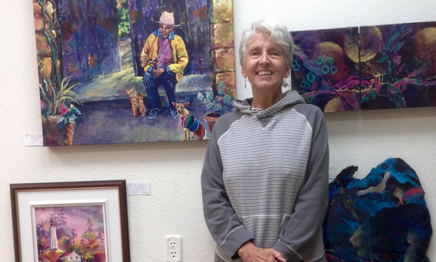 Bonny Roberts posed with some of her paintings on display at the Okanagan Art Gallery.