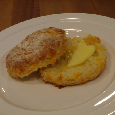 A buttermilk biscuit with strawberry jam and butter looks tasty.