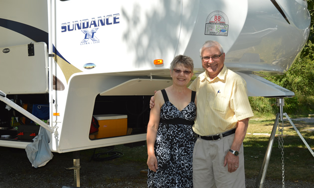 Smiling senior couple beside their RV