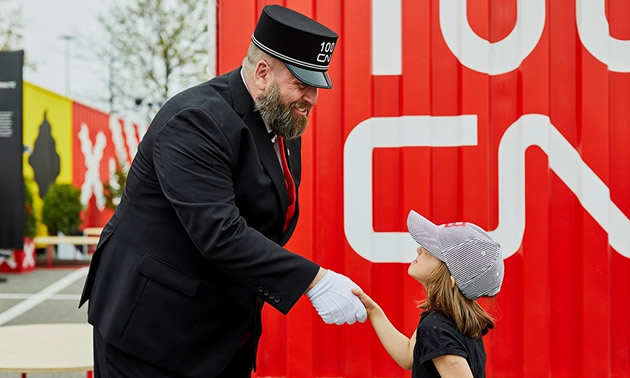 CN conductor shaking hands with young girl. 