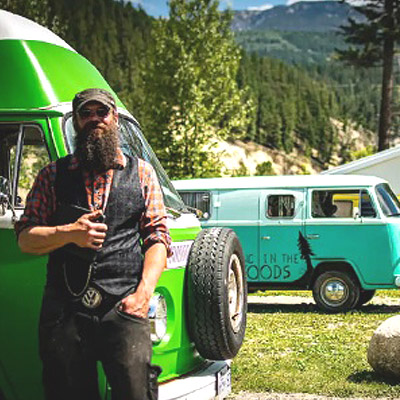 Jeremiah Woods standing in front of row of VW vans. 