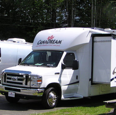 A CanDream rental motorhome with a slideout parked at a campground. 