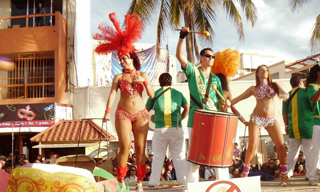 Picture of parade float with dancers on it. 