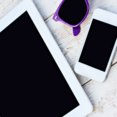 Picture of tablet and cell phone sitting on counter. 