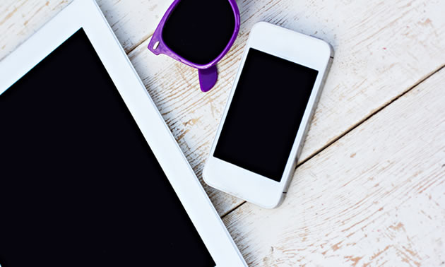 Picture of tablet and cell phone sitting on counter. 