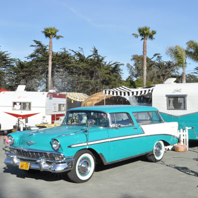 A 1956 tropical turquoise Chevrolet Bel Air along with a matching 1961 Shasta Compact travel trailer.