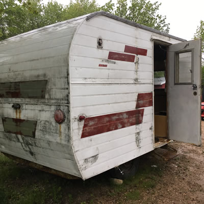 Picture of trailer, with red stripes and damage on back end. 