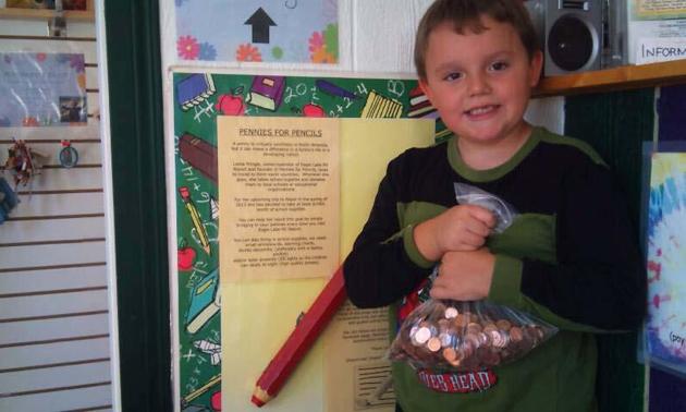 Young boy holding a bag of pennies