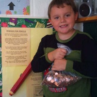 Young boy holding a bag of pennies