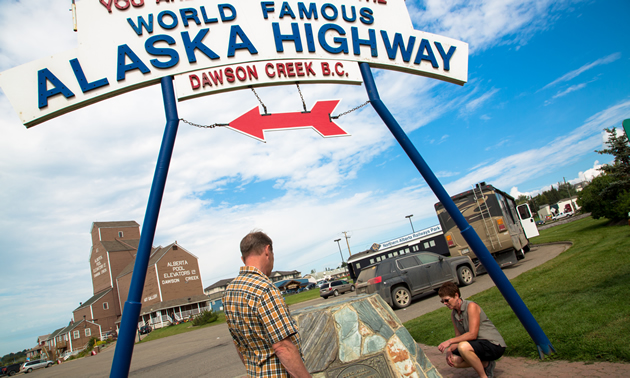 A couple look at the Mile 0 cairn for the Alaska Highway, found in Dawson Creek.