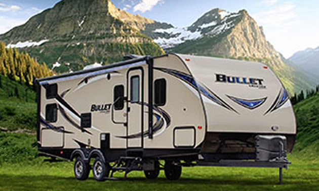 Fifth wheel RV sitting in front of scenic mountain view.