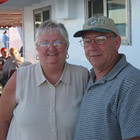 Senior couple stand outside their RV.