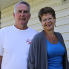 Couple stands outdoors at the door of their office 