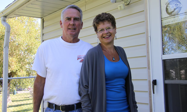 Couple stands outdoors at the door of their office 