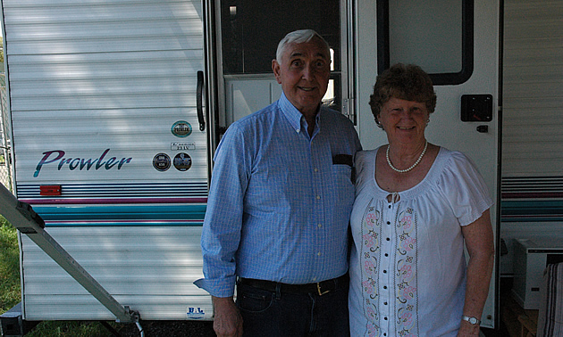 Elderly couple standing beside their RV