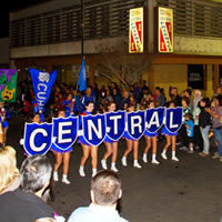 Marching girl group carrying letter-boards spelling 