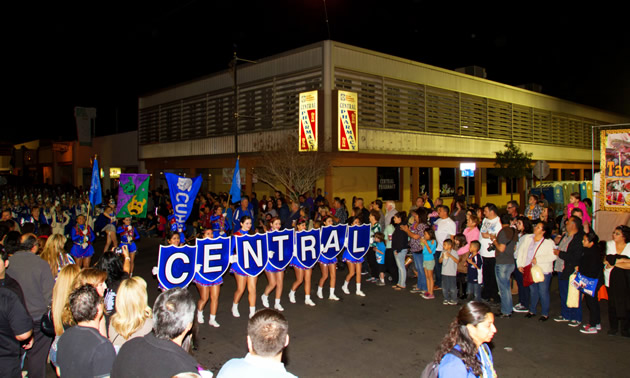 Marching girl group carrying letter-boards spelling 