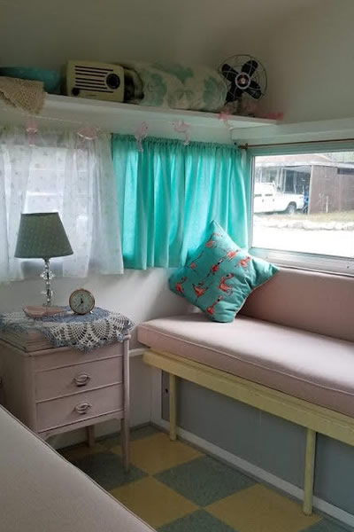 Interior of trailer, with turquoise and pink decor, checkered floor. 